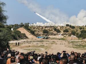 People watch as rockets are fired during a military drill by Palestinian Islamist movement Hamas and other Palestinian armed factions in Gaza City on December 29, 2020. MAHMUD HAMS / AFP