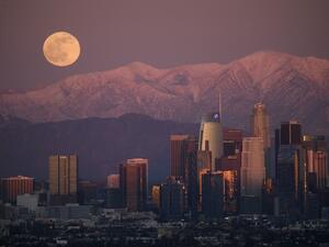 The last full moon of 2020, also known as the Cold Moon, rises behind the snow-topped San Gabriel Mountains and the Los Angeles downtown skyline at sunset as seen from the Kenneth Hahn State Recreation Area on December 29, 2020 in Los Angeles, California. Patrick T. Fallon / AFP