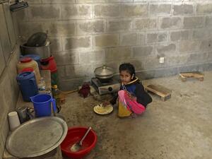 A child of Rohingya refugee eats food inside the room of a housing complex at the Bhashan Char island after they were relocated in Noakhali on December 30, 2020. Mohammad Al-MASUM MOLLA / AFP