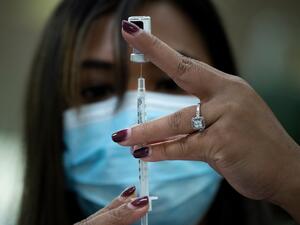 A pharmacist dilutes the Pfizer COVID-19 vaccine while preparing it to administer to staff and residents at the Goodwin House Bailey's Crossroads, a senior living community in Falls Church, Virginia, on December 30, 2020. Brendan Smialowski / AFP