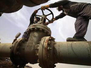 موظفون عراقيون يفتحون صماماً في منشأة نفطية في حقل نهر بن عمر للغاز الطبيعي 
