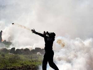 A Palestinian protester returns a tear gas canister amid clashes with Israeli security following a demonstration against the expansion of settlements near the village of Beit Dajan, east of Nablus, in the occupied West Bank, on December 25, 2020. JAAFAR ASHTIYEH / AFP