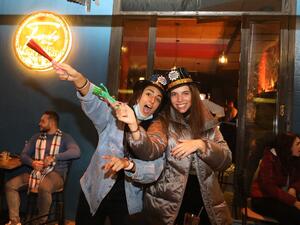 People share a drink to celebrate New Year's eve at a pub in the capital Beirut on January 1, 2021. ANWAR AMRO / AFP