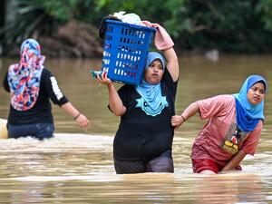 Residents carry their belongings through floodwaters in Kuala Kaung, near Lanchang in Malaysia's Pahang state on January 4, 2021. Mohd RASFAN / AFP