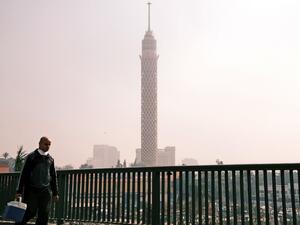 A man walks along the side of the October 6 bridge connecting Egypt's twin districts of Cairo and Giza, over the capital's Nile island of Zamalek on January 6, 2021, while the landmark Cairo Tower is seen in the background. Coptic Christians in Egypt celebrate Christmas on January 7th which is a public holiday in Egypt. Amir MAKAR / AFP