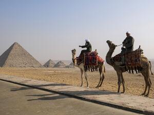 Camel trainers ride camels awaiting tourists by the Pyramid of Menkaure (Menkheres) at the Giza Pyramids Necropolis on the western outskirts of the Egyptian capital's twin city of Giza on January 7, 2021. Amir MAKAR / AFP