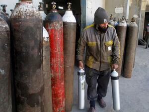 A worker carries oxygen canisters to be used by hospitals treating COVID-19 patients, at a factory in the southern Lebanese city of Sidon (Saida), on January 9, 2021. Since the start of the Covid-19 pandemic, Lebanon has recorded nearly 200,000 cases including 1,537 deaths, according to health ministry figures. AFP