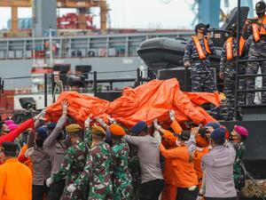 Rescue workers carry recovered debris at the port in Jakarta on January 10, 2021, during the search operation for Sriwijaya Air flight SJY182 which crashed after takeoff from Jakarta on January 9. Dany Krisnadhi / AFP
