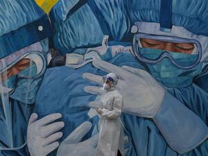 A medical personnel wearing a protective suit waits at the Covid-19 coronavirus drive-thru test centre outside the Ajwa Private Clinic in Shah Alam on the outskirts of Kuala Lumpur on January 12, 2021, as Malaysia's king declared a nationwide state of emergency to fight a coronavirus surge. Mohd RASFAN / AFP