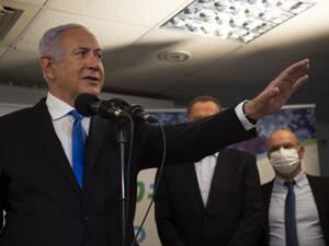 Israel's Prime Minister Benjamin Netanyahu visits the anti-coronavirus vaccination facility in the northern Israeli Arab city of Nazareth on January 13, 2021. A group of Arab Israelis demonstrated against Netanyahu's visit to the fascililty in their city. Since July, thousands of Israelis have rallied each week to protest against the prime minister and the economic fallout from the pandemic. Gil ELIYAHU / POOL / AFP