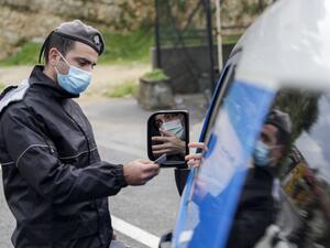 A member of the Lebanese security forces checks a citizen's documents at a COVID-19 checkpoint near the coastal town of Safra on the Tripoli-Beirut main highway on January 19, 2021, as Lebanon enters a second week under lockdown aimed at preventing the country's creaking healthcare system from collapsing. JOSEPH EID / AFP