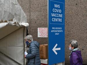 People attend a Covid-19 vaccination centre in Wembley, northwest London, on January 19, 2021. Britain on January 18 extended its coronavirus vaccination campaign to people over the age of 70, as new, tougher restrictions for all arrivals to the country came into force. JUSTIN TALLIS / AFP