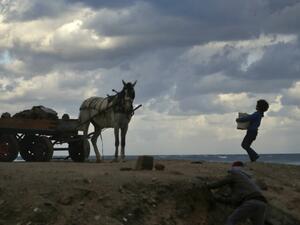 A Palestinian children help their father to collect rubble to sell it in Gaza City on January 20, 2021. Mohammed ABED / AFP