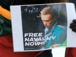 A participant holds a poster with a photo taken by AFP photographer Kirill Kudryavtsev on January 17, 2021, which shows Russian opposition leader Alexei Navalny upon arrival at Moscow's Sheremetyevo airport, during a demonstration in support of Navalny, who is currently jailed, in front of the Russian embassy in Vilnius, on January 23, 2021. Small protests in support of jailed Kremlin critics Alexei Navalny were held in the Baltic states of Lithuania ad Estonia on January 23. Navalny, 44, called on his alli