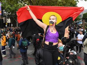 People hold placards as thousands of people attend an Australia Day protest in Melbourne in January 26, 2021. William WEST / AFP
