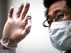 A medical personnel presents a containers with water, which are used to preserve the vaccinnes in a deep freezer during a Covid-19 coronavirus vaccination drill at the Kawasaki City College of Nursing in Kawasaki on January 27, 2021. Philip FONG / AFP