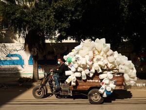 A Palestinian man rides his vehicle loaded with empty plastic containers that were collected from the street for recycling, in Gaza City, on January 31, 2021. MOHAMMED ABED / AFP