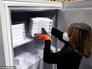 Jessica Mueller puts supplies of the Pfizer/BioNTech vaccine into an ultra-cold freezer at a warehouse near Magdeburg today, amid concern in Brussels over a separate bilateral deal between Berlin and the vaccine developers. AFP