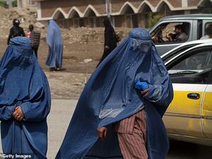 Two Afghan burqa-clad women walk along a street in Kabul, Afghanistan, on May 6, 2010 (AFP/file photo)
