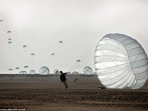 Tuesday's drill is the latest in a series of military exercises by Iran. On Friday, the Iranian Revolutionary Guard Corps' aerospace division launched surface-to-surface ballistic missiles and drones against 'hypothetical enemy bases'. Pictured: A paratrooper lands during a drill by the Iranian military on Tuesday. (AFP)