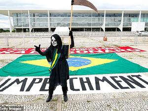 A demonstrator representing the grim reaper standing in front of an 'impeachment' banner takes part in a protest against Brazil's President Jair Bolsonaro measures to confront the COVID-19 coronavirus pandemic, January 17. (AFP)