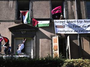 Boycott, Divestment, Sanctions (BDS) movement activists display Palestinian flags and a banner reading "Israel Start-Up Nation, Tour de France is the accomplice of the apartheid" as the pack rides during the 13th stage of the 107th edition of the Tour de France cycling race, 191 kilometers between Chatel-Guyon and Puy Mary, on Sept. 11, 2020. Photo by MARCO BERTORELLO/AFP via Getty Images