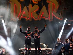 Mini's driver Stephane Peterhansel and his co-driver Edouard Boulanger of France celebrate their victory on the podium after winning the Dakar Rally 2021. (Photo: FRANCK FIFE / AFP)