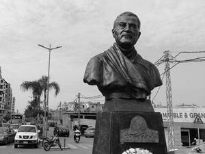 A photo taken on January 5, 2021 shows a Lebanese flag hanging on a building under construction behind the newly unveiled statue of Iran's most revered military commander, Qasem Soleimani, in the predominantly-Shiite Muslim Beirut southern suburb of Ghobeiry. Soleimani -- whom the US blamed for attacks on its interests in Iraq and elsewhere -- was killed in a US drone strike at Baghdad airport on January 3 last year, ratcheting up tensions between decades-old arch foes the United States and Iran. JOSEPH EID