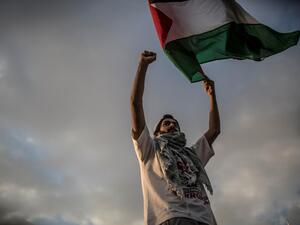 A man waves a Palestinian flag during a protest to mark Nakba Day (AFP)