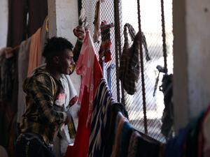 A man looks out of a window inside a school building for displaced Yemenis who fled fighting between Huthi rebels and the Saudi-backed government forces, in the town of al-Turba in Taez governorate on February 4, 2021. AHMAD AL-BASHA / AFP