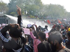 A police vehicle fires water cannon in an attempt to disperse protesters during a demonstration against the military coup in Naypyidaw on February 8, 2021 STR / AFP