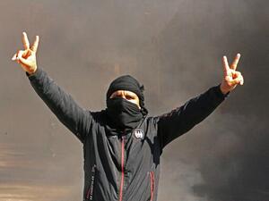 A Tunisian man flashes the V for victory sign as youths burn tires and block roads in the southern city of Tataouine, on February 12, 2021, to protest against the government's failure to keep its promise to provide jobs and investments.  FATHI NASRI / AFP