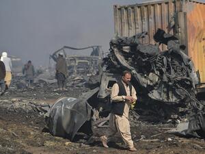 Afghan men walks past the wreckage of gas tankers after a fire accident at Islam Qala on the outskirts of Herat, in the border between Afghanistan and Iran on February 14, 2021. HOSHANG HASHIMI / AFP