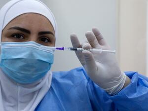 A member of the healthcare staff prepares a dose of the COVID-19 Pfizer/BioNTech vaccine at Lebanon's Rafik Hariri Hospital in the capital Beirut, on February 14, 2021, as the country kickstarts its inoculation campaign. Lebanon gave its first COVID-19 vaccine dose to a doctor, as it started inoculation it hopes will keep the pandemic in check amid a deepening economic crisis. ANWAR AMRO / AFP