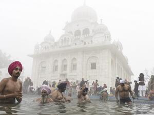 Sikh devotees take a holy dip in the Sarovar (water tank) during Basant Panchami celebrations at the Sikh Shrine Gurudwara Chheharta Sahib on the outskirts of Amritsar on February 16, 2021. NARINDER NANU / AFP