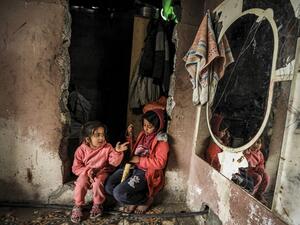 Palestinian girls sit together next to a wall-mounted mirror in their home in an impoverished neighbourhood during stormy weather in Gaza City on February 17, 2021. MAHMUD HAMS / AFP