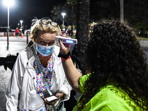 Attendees get their temperature checked as they arrive for the performance of "La Bohème" on stage for the first mainstream opera performance in the US since the beginning of the Covid-19 pandemic, organized by the Palm Beach Opera's outdoor festival at the iTHINK Financial Amphitheater in West Palm Beach, on February 19, 2021.  AFP