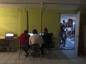 Emma Moreno (R), a volunteer working at the Agape shelter, checks the "Conecta" website of the United Nations High Commissioner for Refugees (UNHCR), to help asylum seekers request appointments and await asylum processes in the US, in Tijuana, Baja California state, Mexico on February 20, 2021. Guillermo Arias / AFP