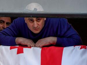 Georgian leader of the United National Movement (UNM) Nika Melia, shouts from a window of his party's headquarters as the police raids the building in Tbilisi on February 23, 2021. Georgian police arrested Melia, the leader of the country's main opposition party, and used tear gas in a violent raid on his party headquarters, further deepening a political crisis sparked by last year's disputed parliamentary elections. Vano Shlamov / AFP