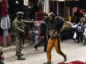 A paramilitary trooper gestures to a pedestrian during a random search in Srinagar on February 26, 2021. Tauseef MUSTAFA / AFP