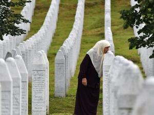 A Bosnian Muslim woman kisses the tombstones of her sons who were killed in the massive killing of Srebrenica during Bosnia's 1992-95 war.
