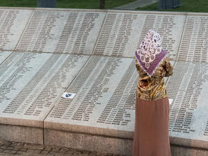 Muslim woman in front of Wall of names at Memorial center Potocari  (Shutterstock)	