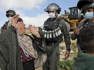 Palestinian women confronts armed Israeli soldiers 