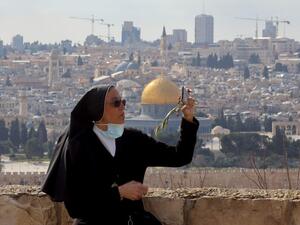 A nun takes a selfie during a Palm Sunday 