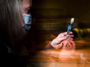  Adams 12 Five Star Schools District RN Tiffany Karschamroon draws a dose from a vial of the Johnson & Johnson COVID-19 vaccine