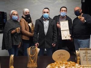 أحمد أبو سنينة يتوسط موظفيه وأكوام من الذهب