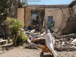 امرأة تسير أمام منزل مدمر في مدينة ووكرو في شمال ميكيلي في إقليم تيغراي