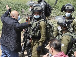 A Palestinian confronts Israeli soldiers