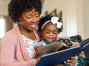 Mother reading a book to her daughter