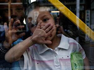 Migrants and refugees wait to be transported to the new state-run facilities